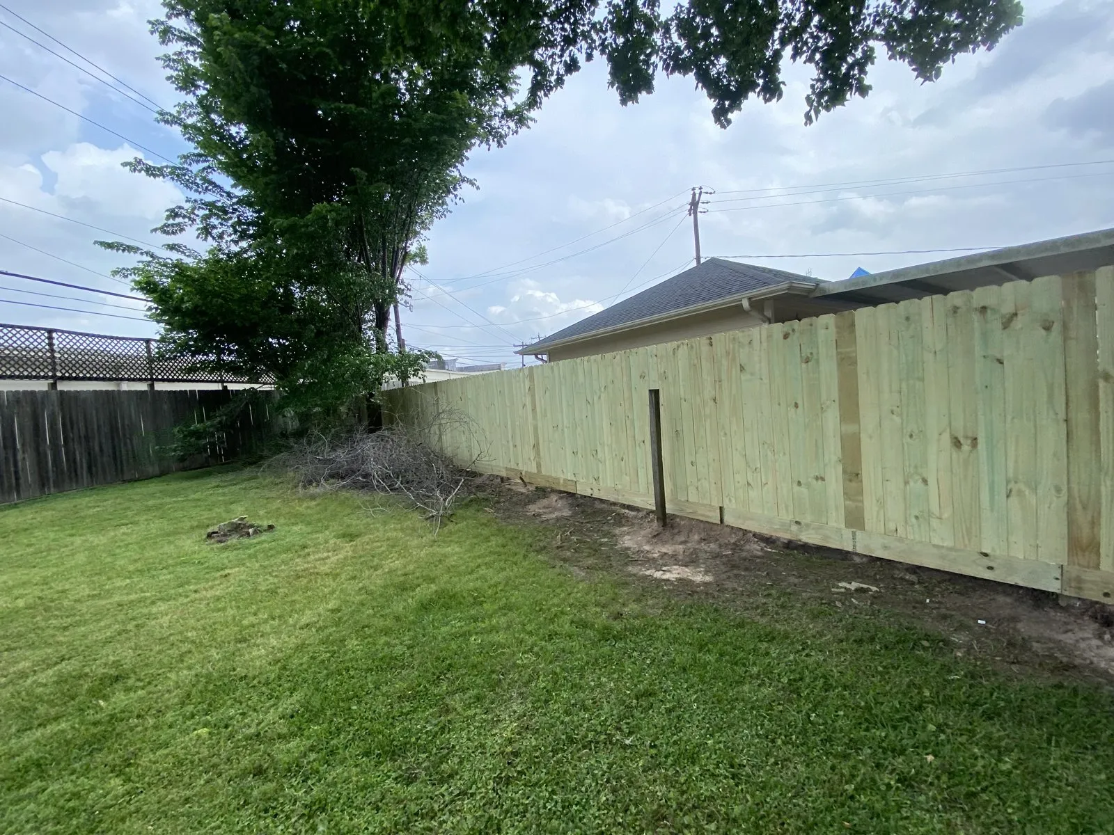 Wood privacy fencing along the edge of a backyard lawn
